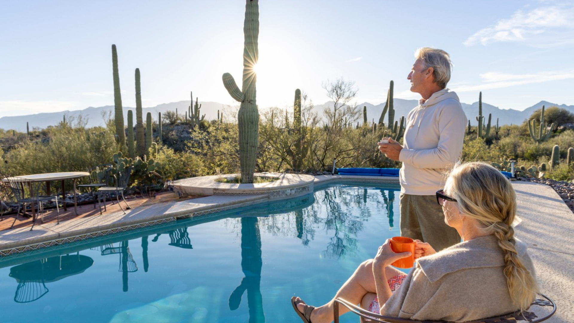 Guests enjoying peaceful desert poolside setting with saguaro cacti and mountain views